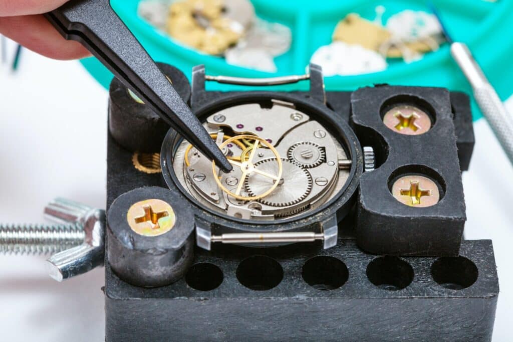 repairing of watch in holder with tweezer close up